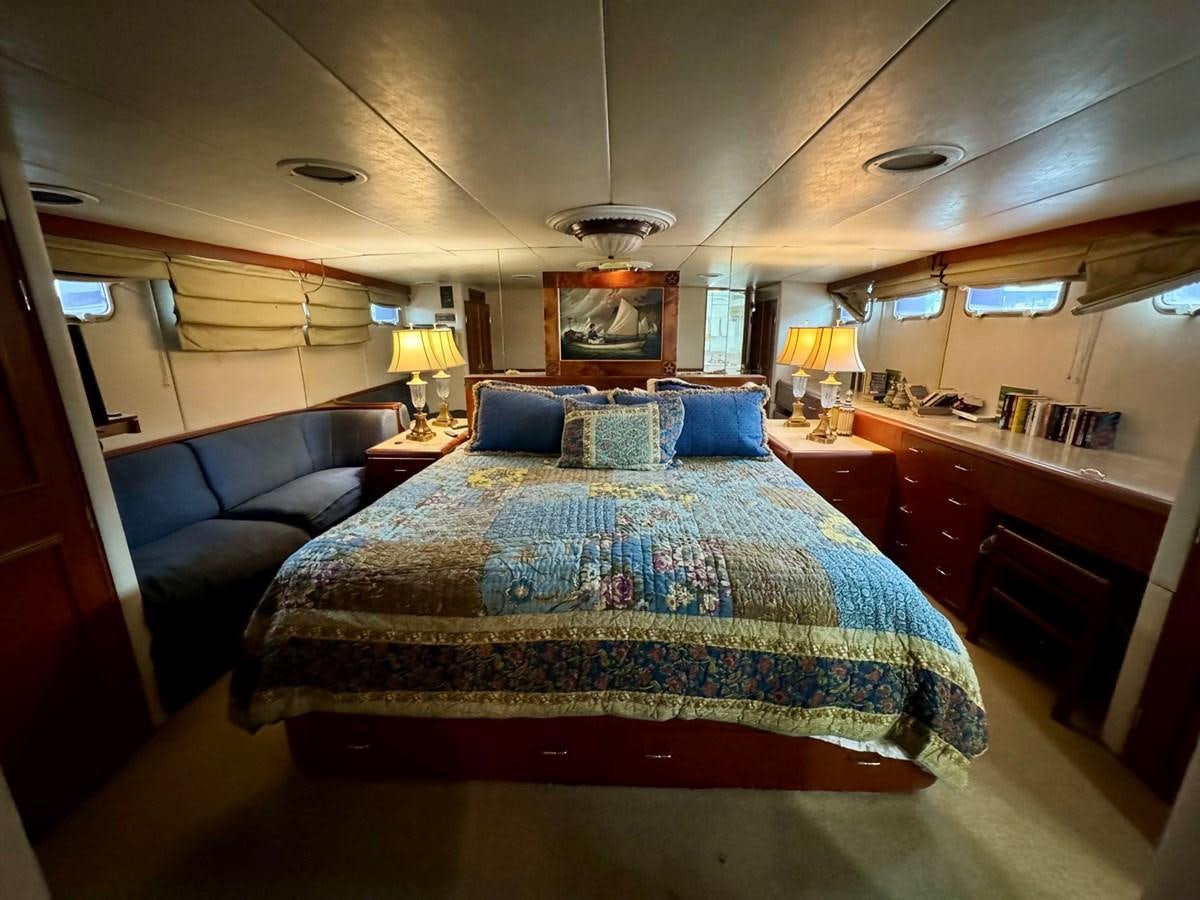 a bedroom with a bed and a desk aboard BRAVEHEART Yacht for Sale