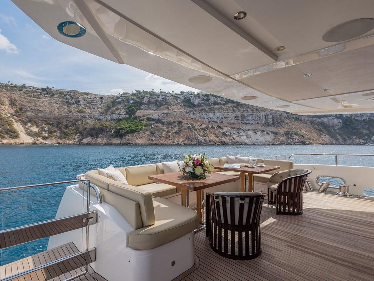 a table and chairs on a deck overlooking a body of water aboard ACE 2 Yacht for Sale