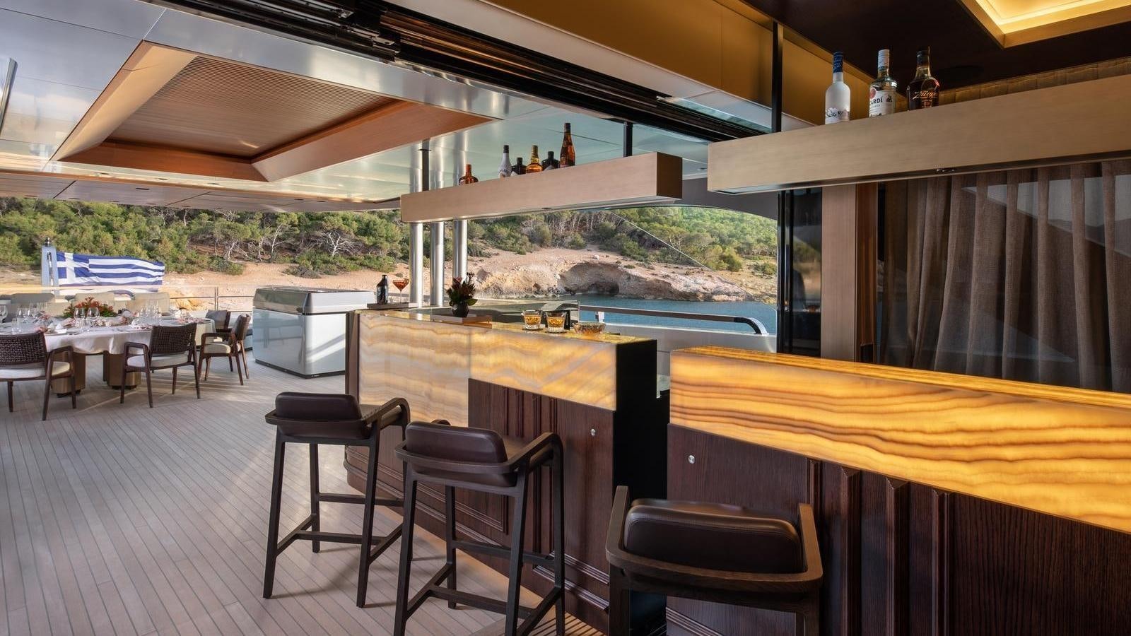 a room with a table chairs and a large body of water aboard GECO Yacht for Sale