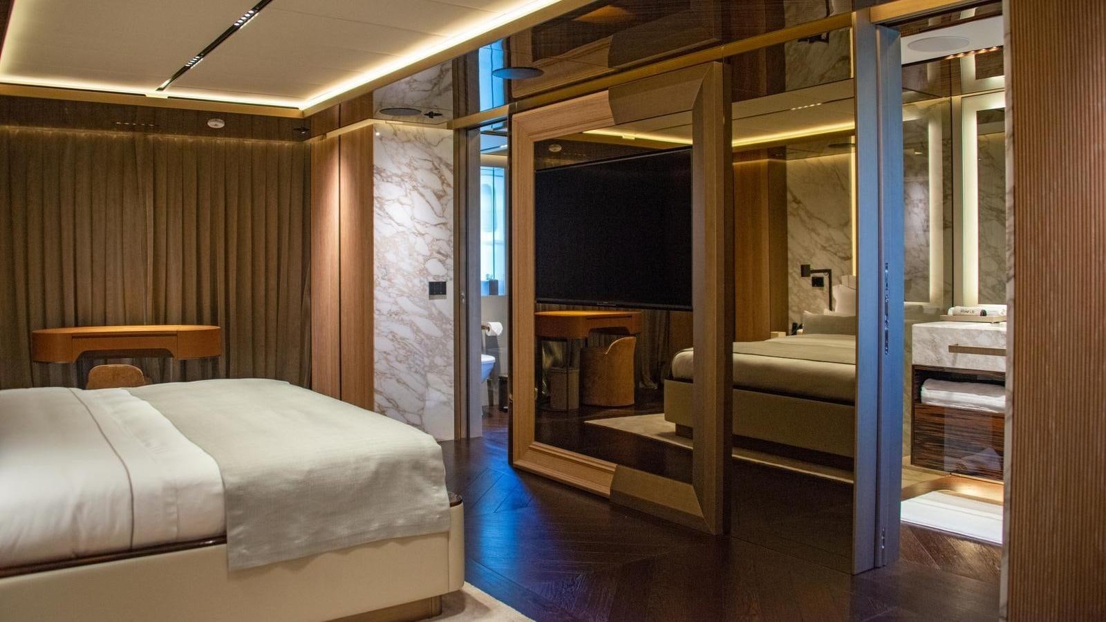 a room with a bed and a mirror aboard GECO Yacht for Sale