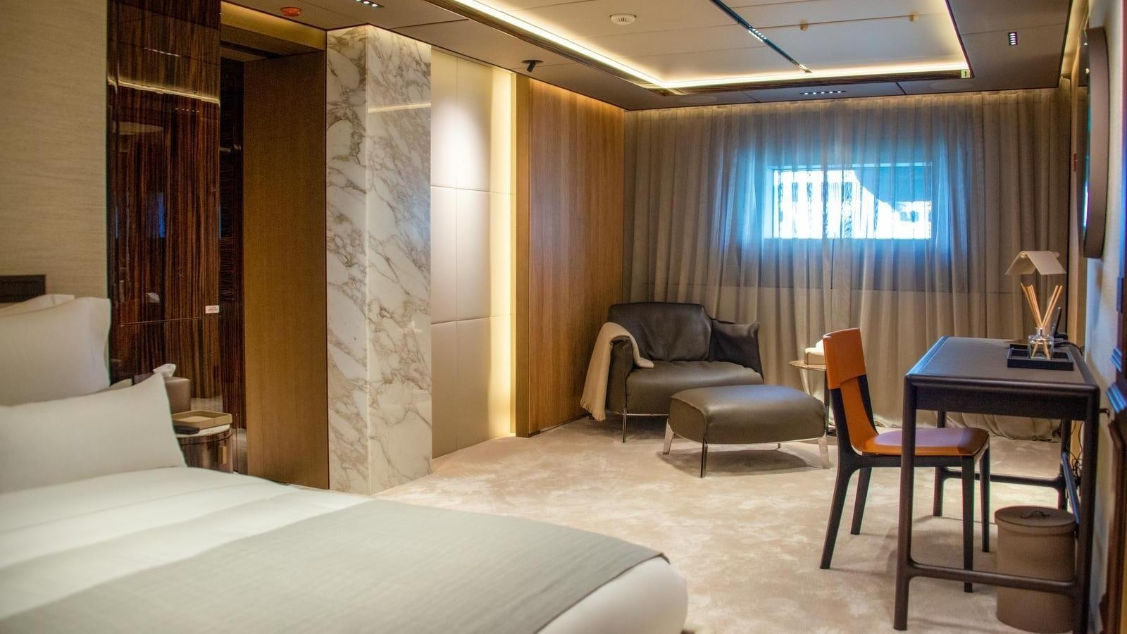 a hotel room with a bed and desk aboard GECO Yacht for Sale