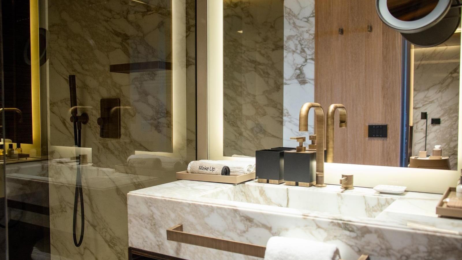 a bathroom with a bathtub and sinks aboard GECO Yacht for Sale