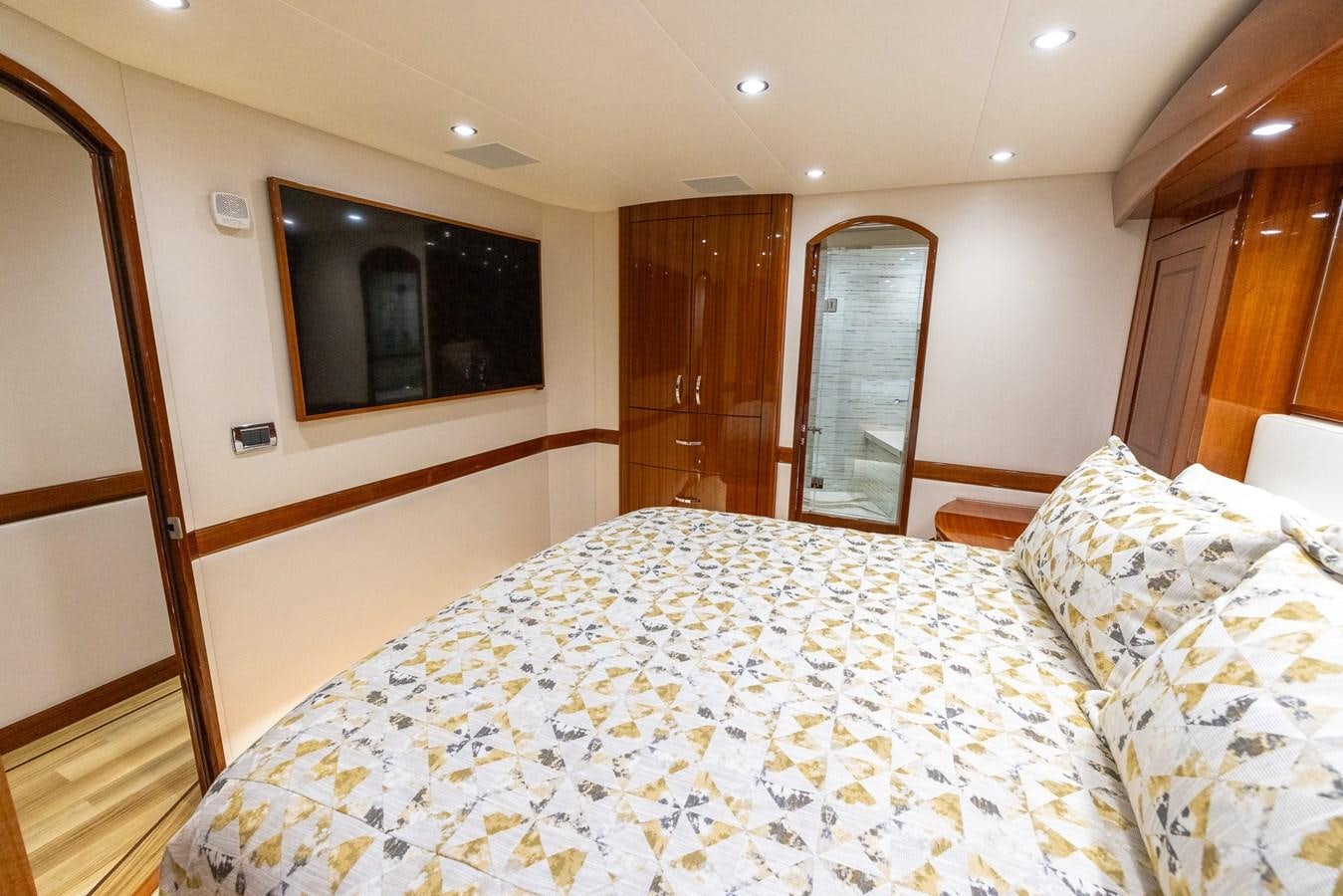 a bed with a television on the wall aboard GT 70 Yacht for Sale