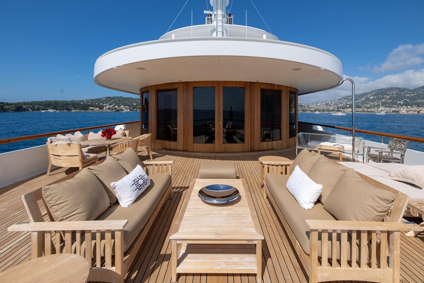 a deck with a view of the ocean and a large building aboard WEDGE TOO Yacht for Sale