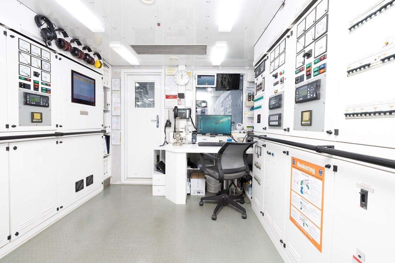 a room with white cabinets and a chair and a desk with a computer aboard WEDGE TOO Yacht for Sale