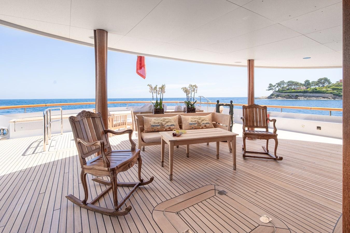 a deck with chairs and a table aboard WEDGE TOO Yacht for Sale
