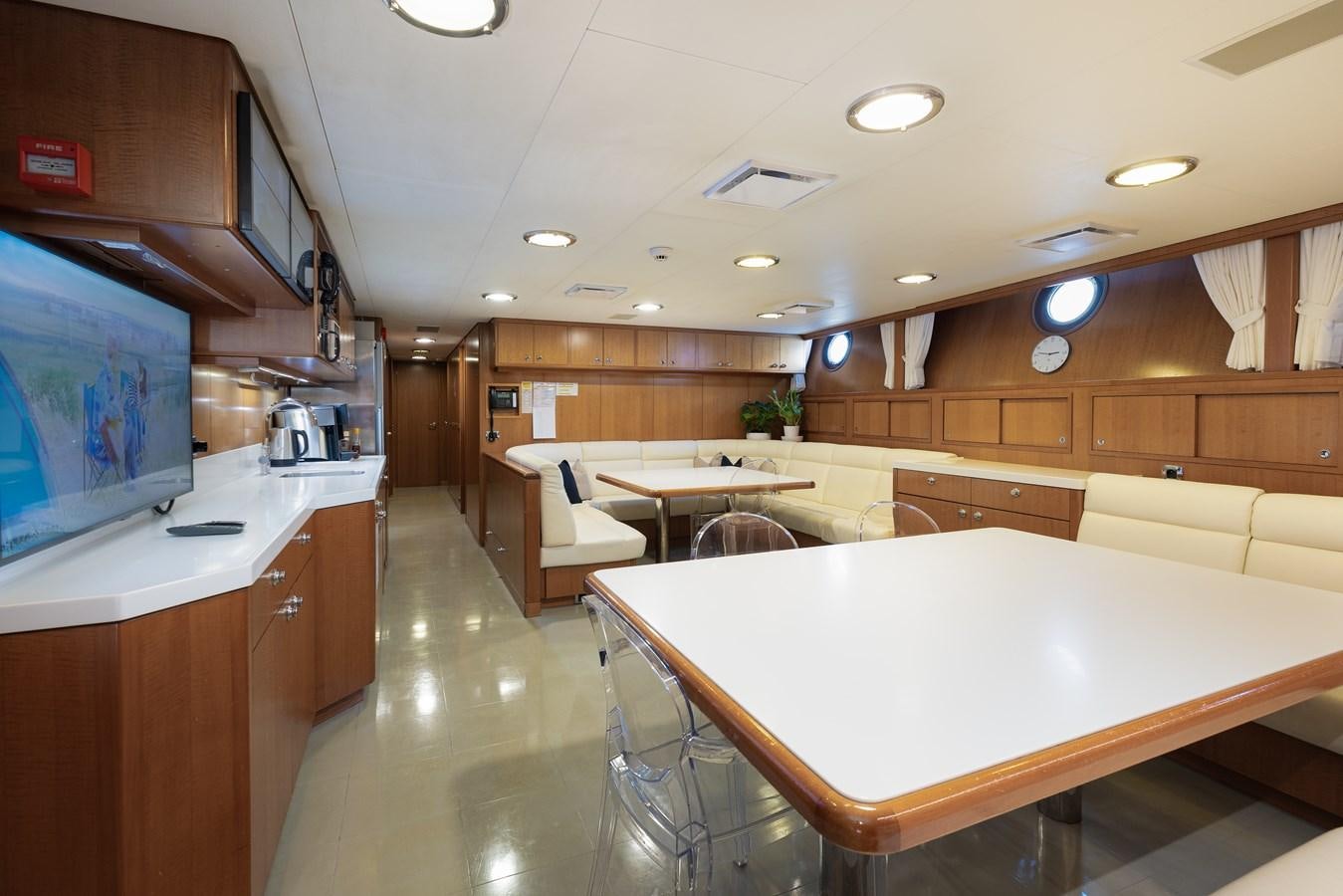 a large room with a table and chairs aboard WEDGE TOO Yacht for Sale