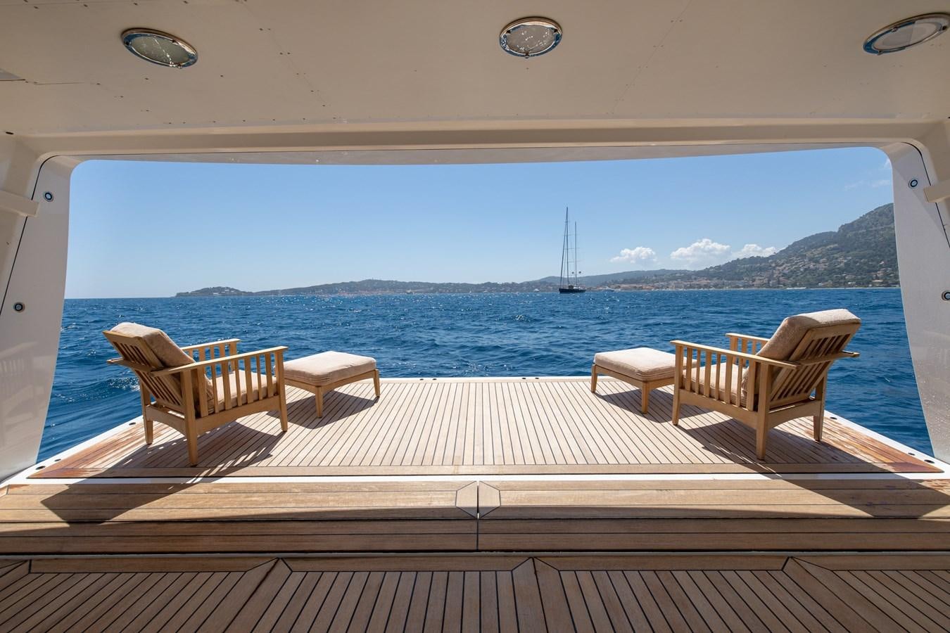a deck with chairs and a view of the ocean aboard WEDGE TOO Yacht for Sale