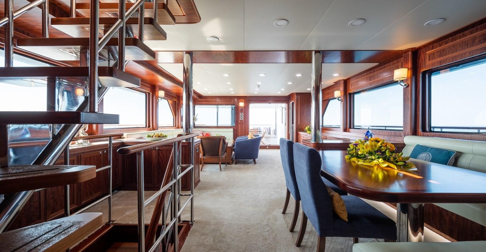 a room with a table chairs and a large window aboard BEYOND CAPRICORN Yacht for Sale