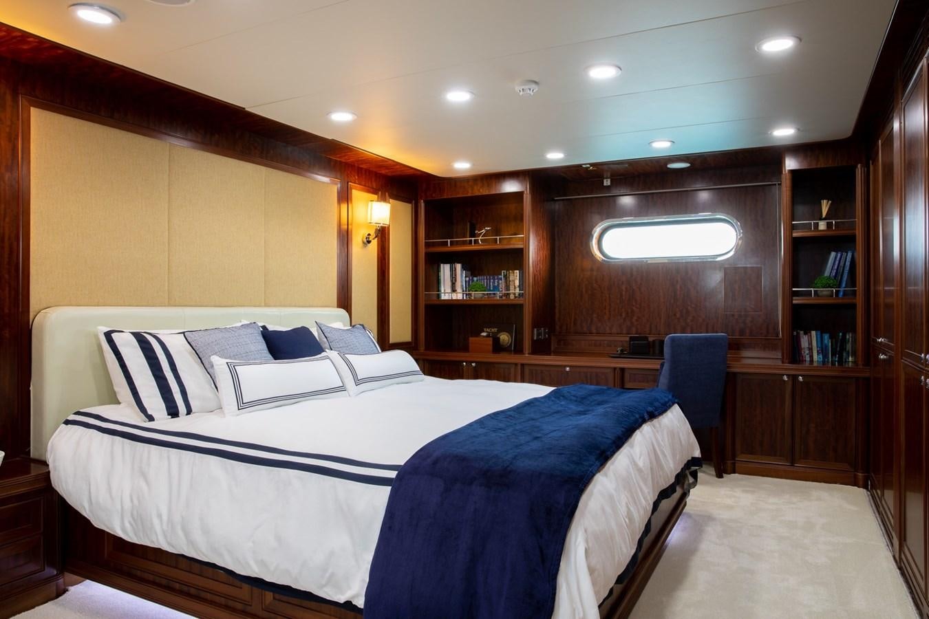 a room with a bed and a bookcase aboard BEYOND CAPRICORN Yacht for Sale