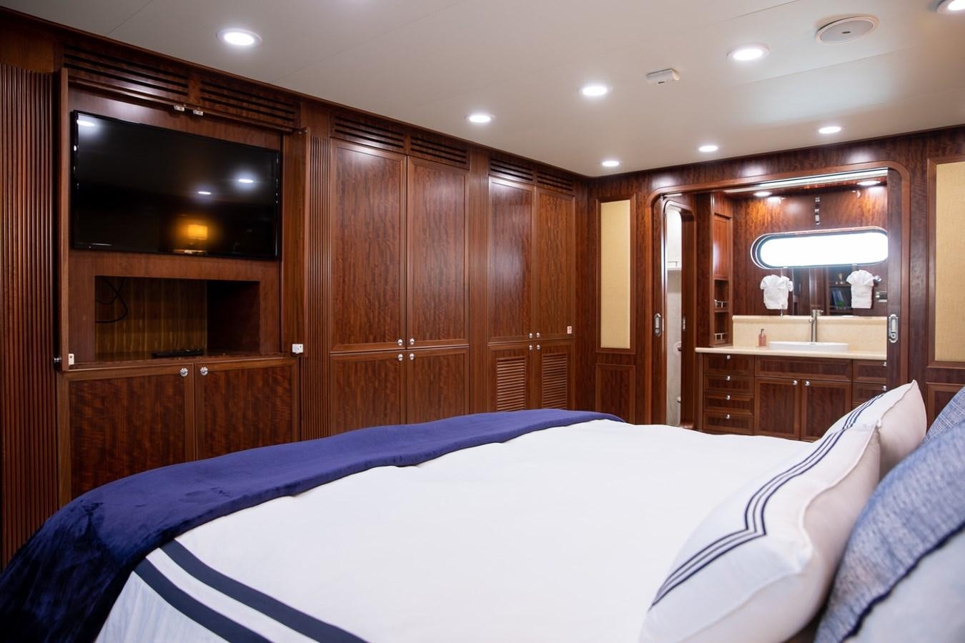 a bedroom with a bed and a cupboard aboard BEYOND CAPRICORN Yacht for Sale