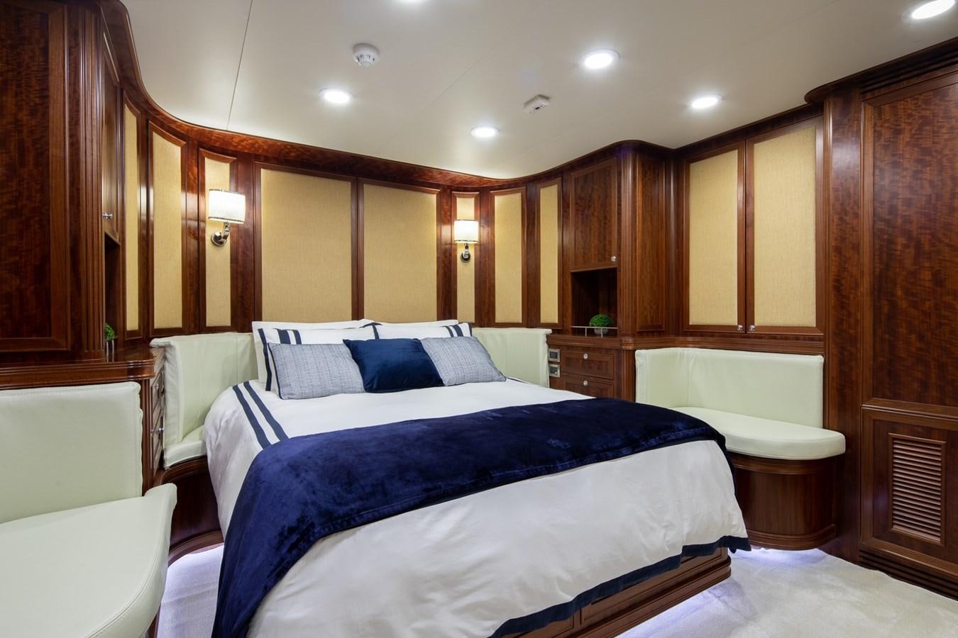 a bedroom with a bed and a desk aboard BEYOND CAPRICORN Yacht for Sale