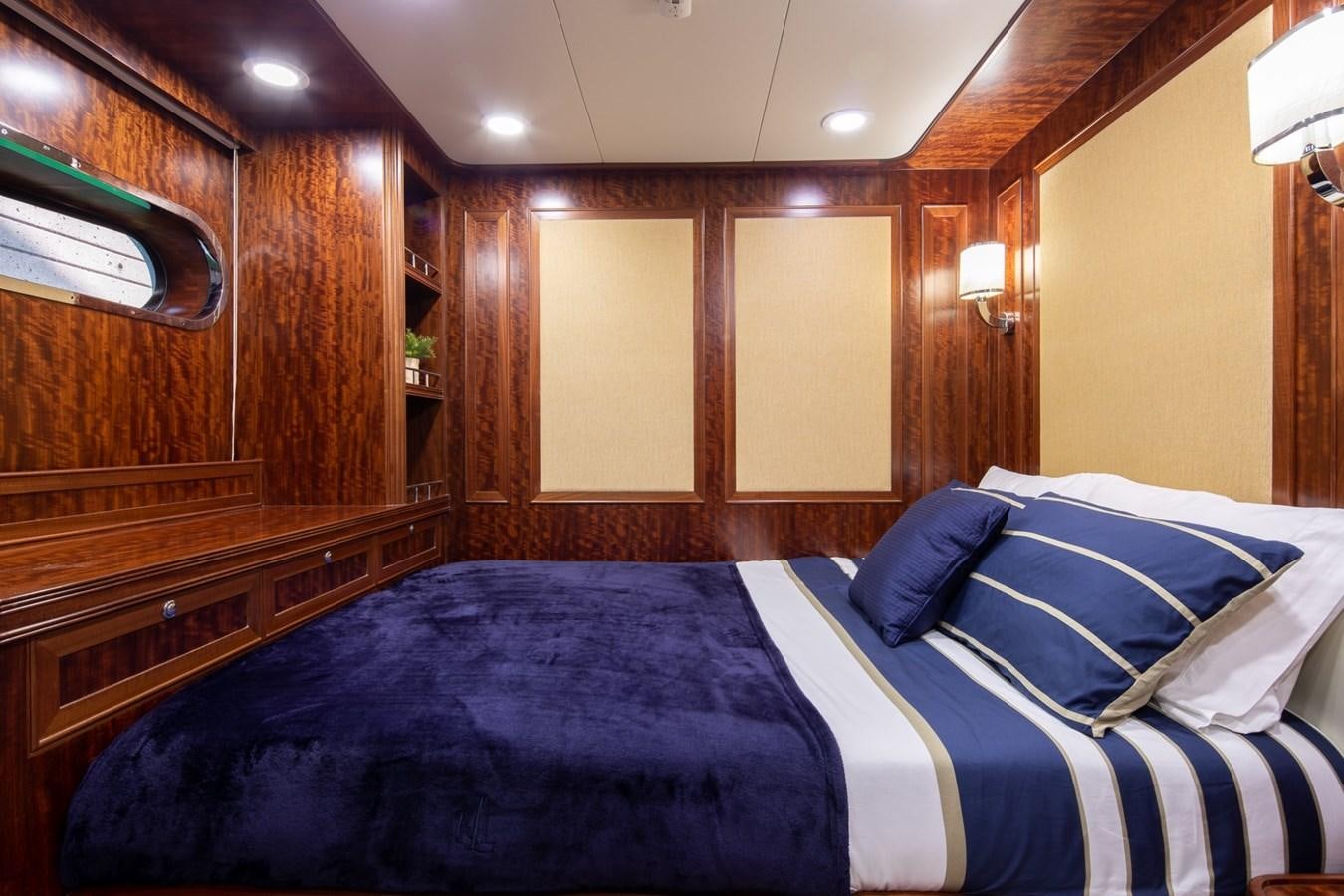 a bed with blue sheets aboard BEYOND CAPRICORN Yacht for Sale