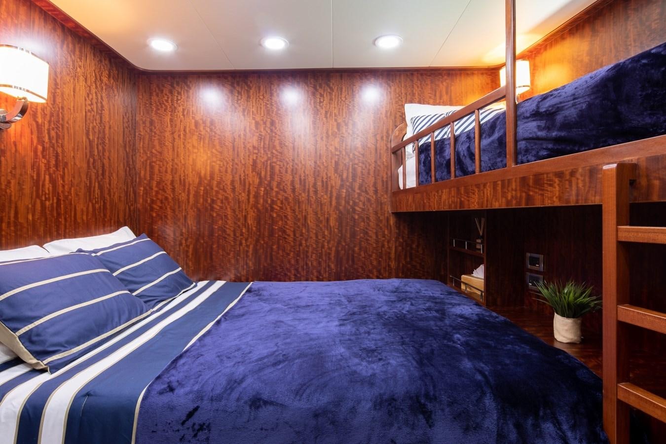 a bed with a blue comforter aboard BEYOND CAPRICORN Yacht for Sale