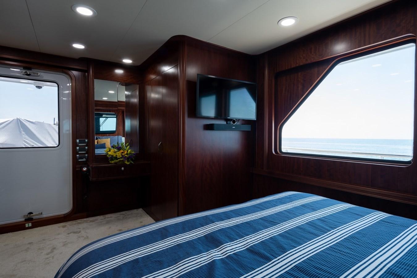 a bedroom with a bed and a window aboard BEYOND CAPRICORN Yacht for Sale