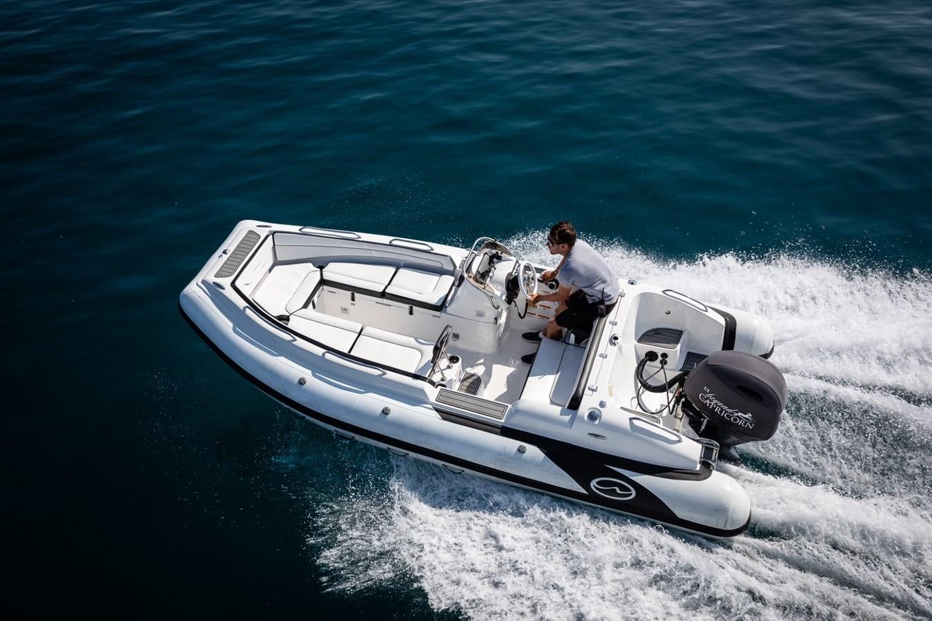 a person driving a boat on the water aboard BEYOND CAPRICORN Yacht for Sale
