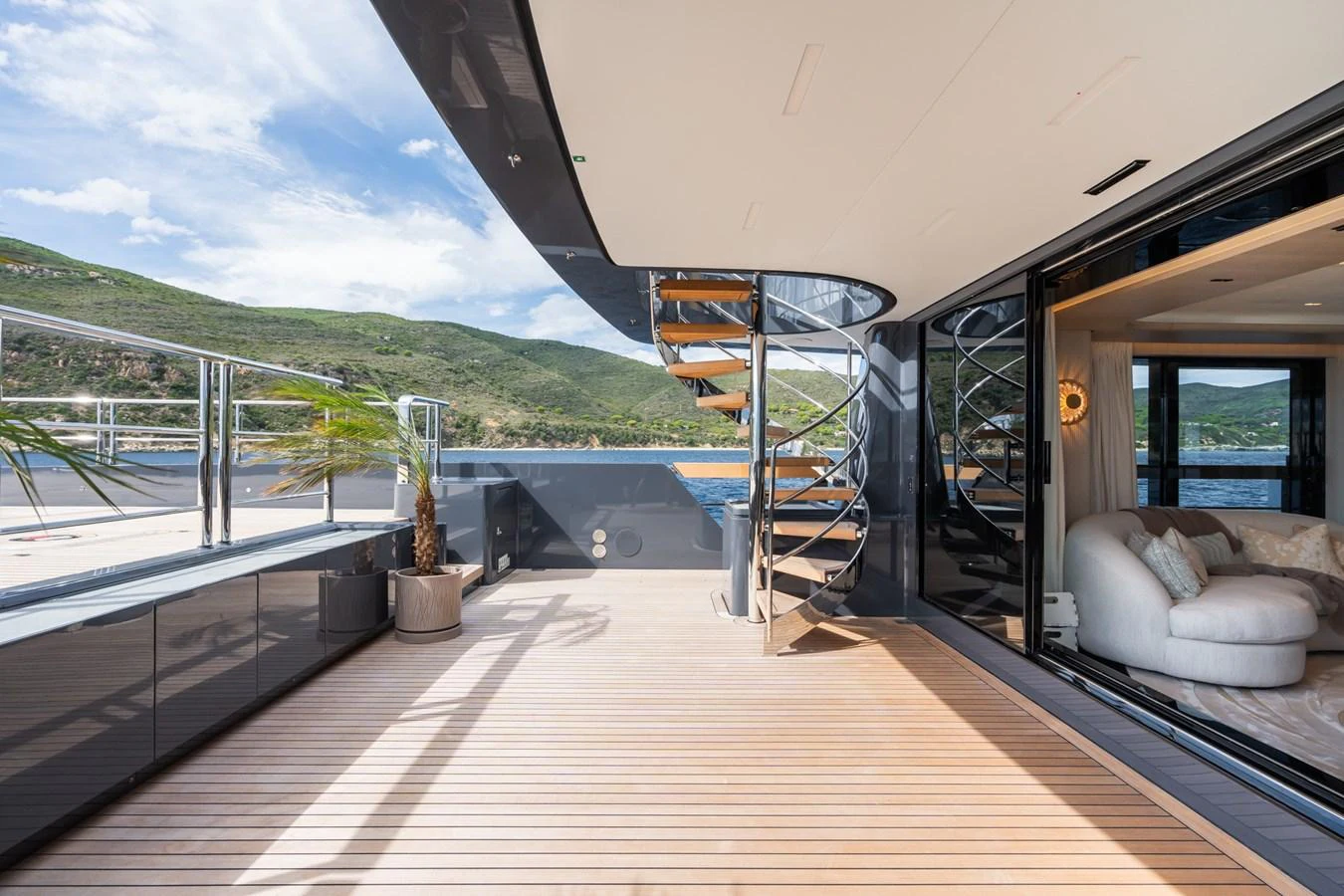 inside of a vehicle with a railing and a railing and a body of water and grass and hills aboard M Yacht for Sale