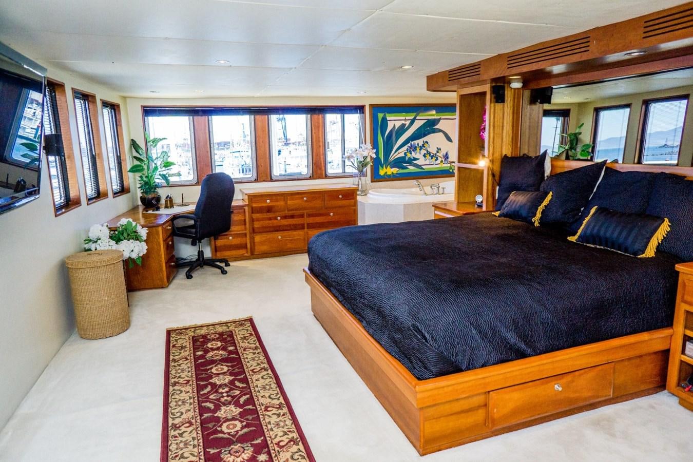 a large living room with a black couch and a black bed aboard BEAUPORT Yacht for Sale