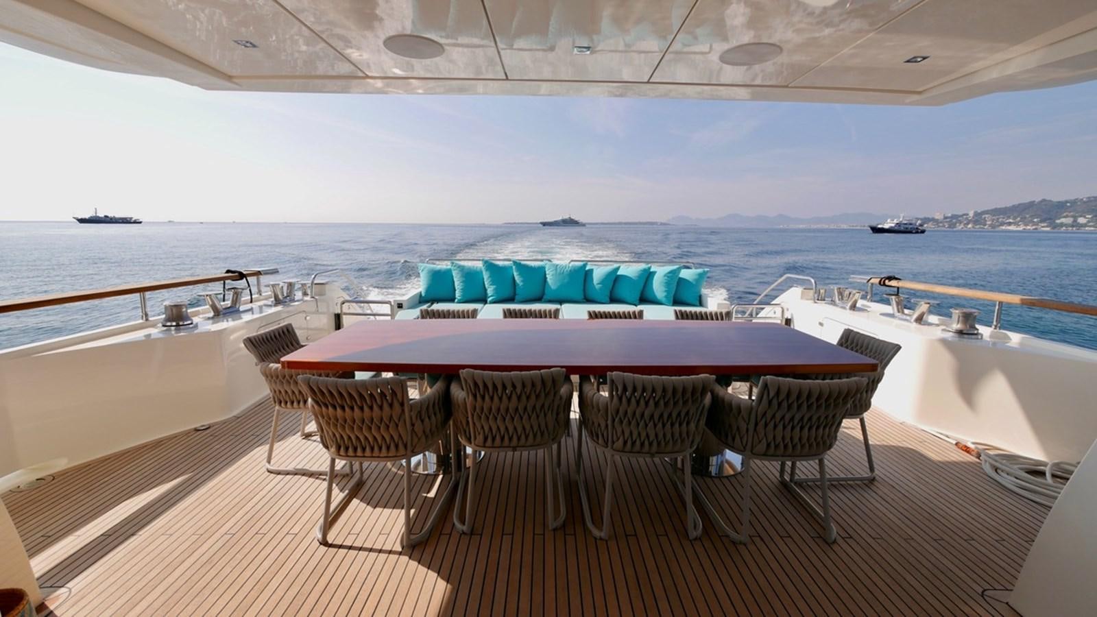 a table and chairs on a deck overlooking a body of water aboard ASCENSION Yacht for Sale