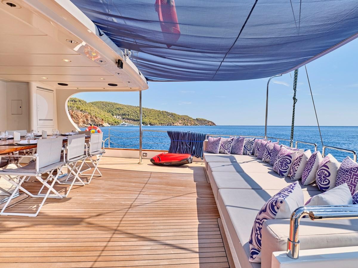 a deck with chairs and tables on it aboard BOOBALE Yacht for Sale