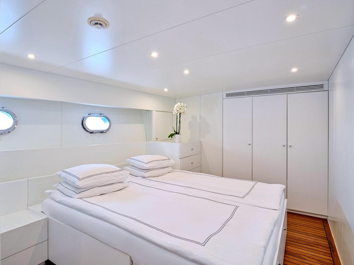 a white bathroom with a large white countertop and a white tile wall aboard BOOBALE Yacht for Sale