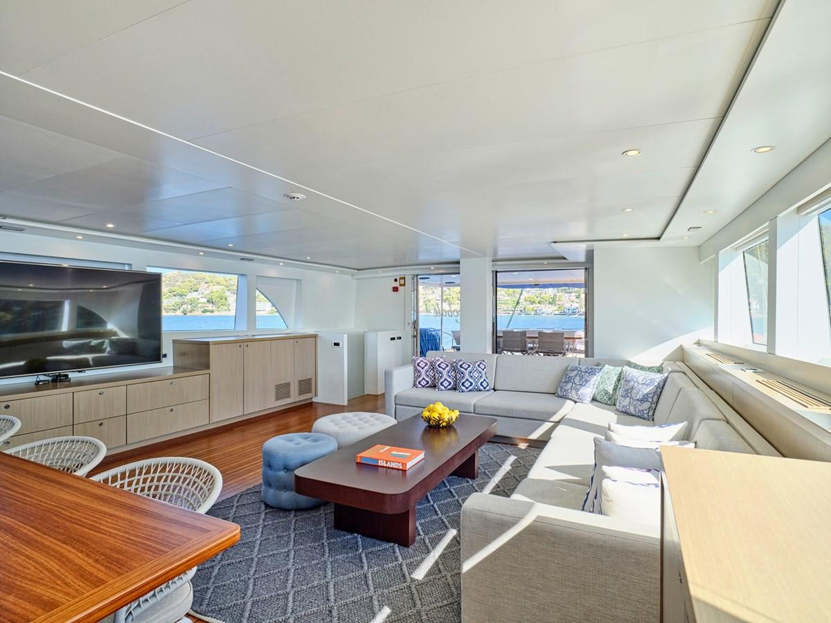 a living room with a table and couches aboard BOOBALE Yacht for Sale