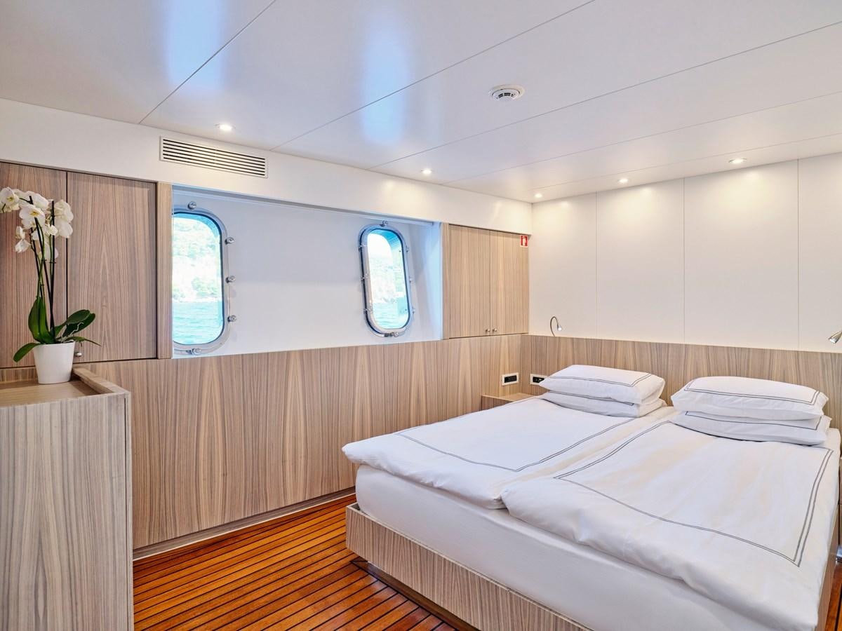 a room with a bed and a window aboard BOOBALE Yacht for Sale