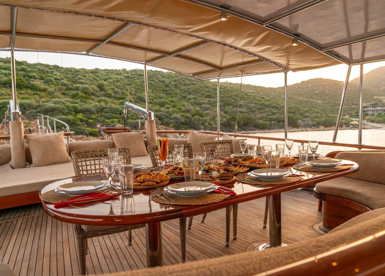a table set with plates and glasses aboard L'ORIENT Yacht for Sale