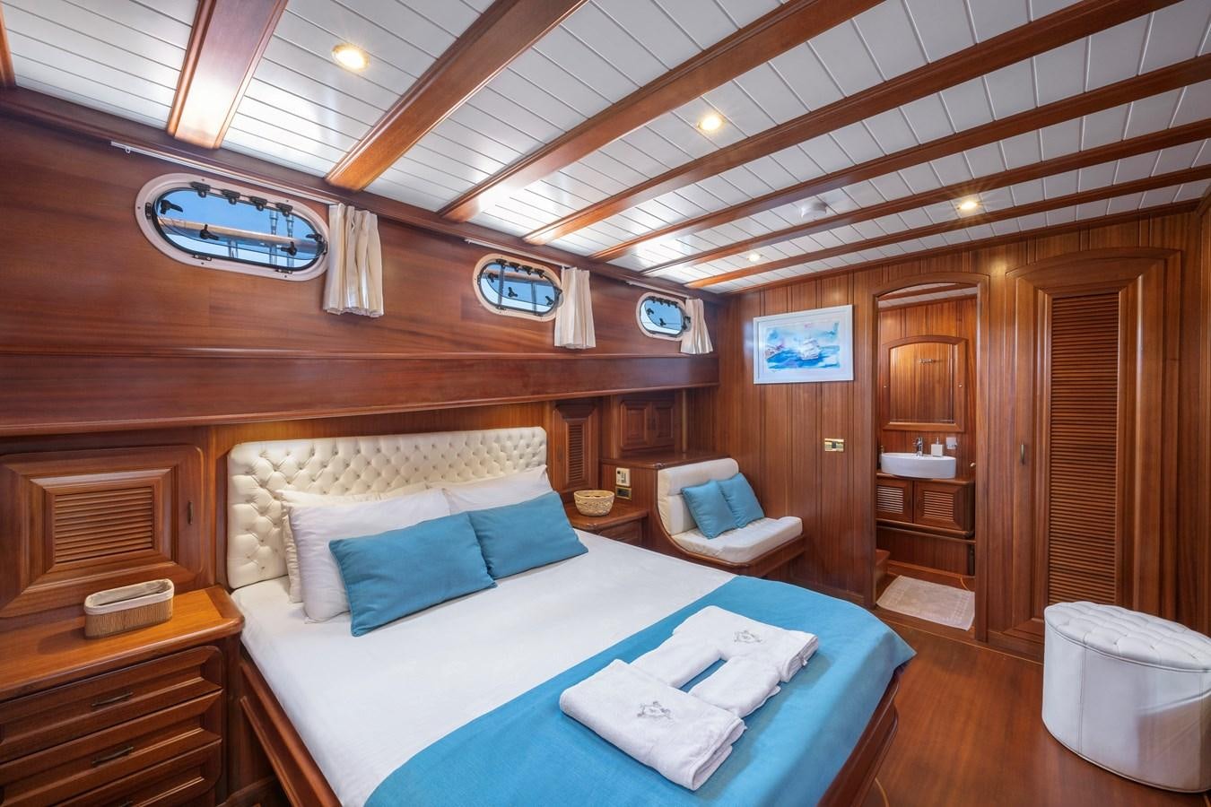 a room with a bed and a chair aboard L'ORIENT Yacht for Sale