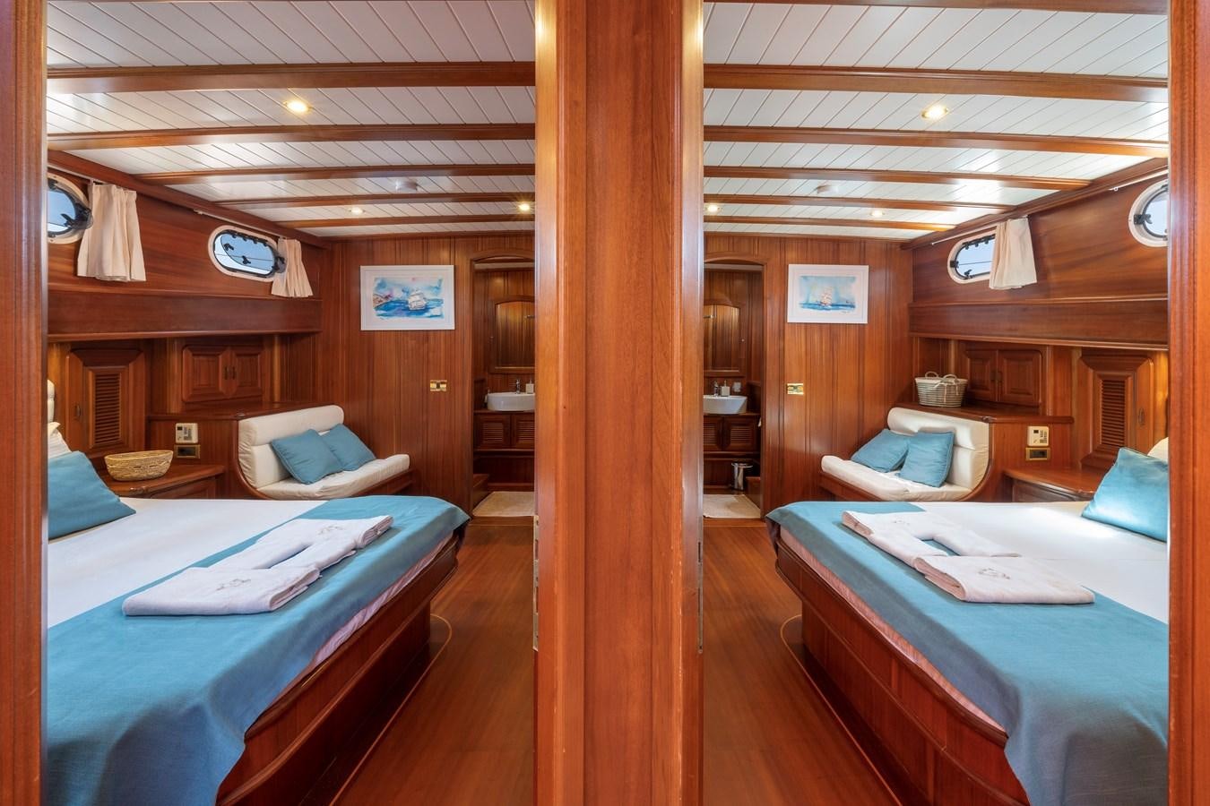 a room with beds and a couch aboard L'ORIENT Yacht for Sale