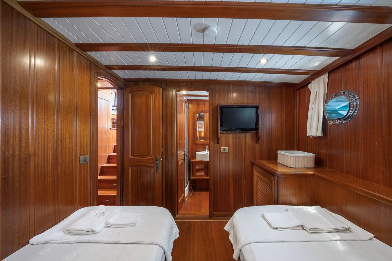 a room with a bed and a television aboard L'ORIENT Yacht for Sale