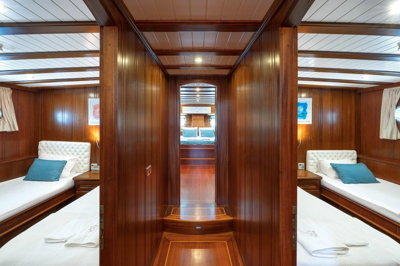 a room with a bed and a wood wall aboard L'ORIENT Yacht for Sale