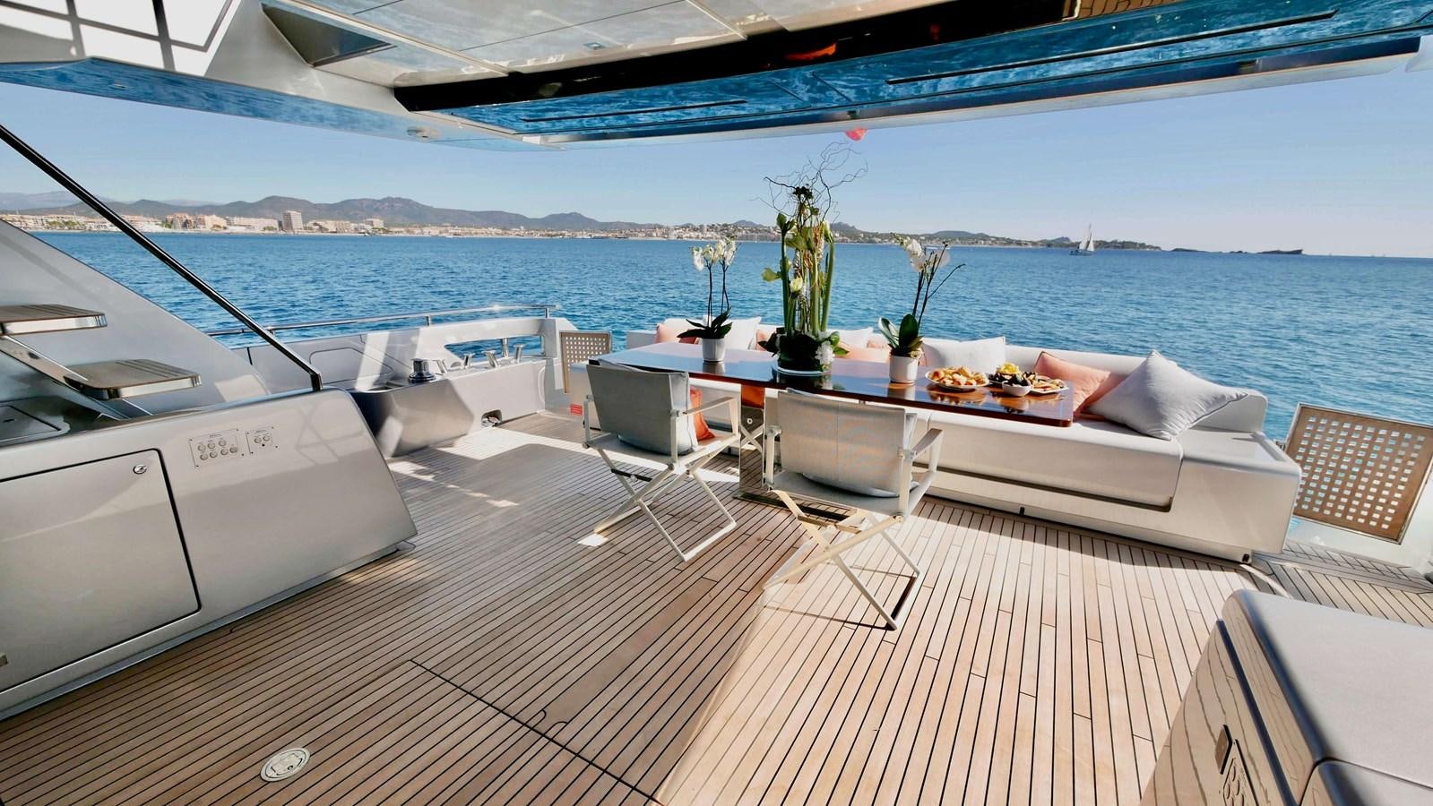 a deck with a table and chairs on it aboard BASILIC Yacht for Sale