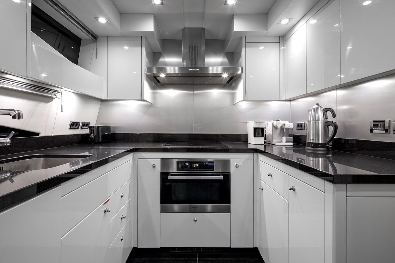 a kitchen with white cabinets aboard SSM Yacht for Sale
