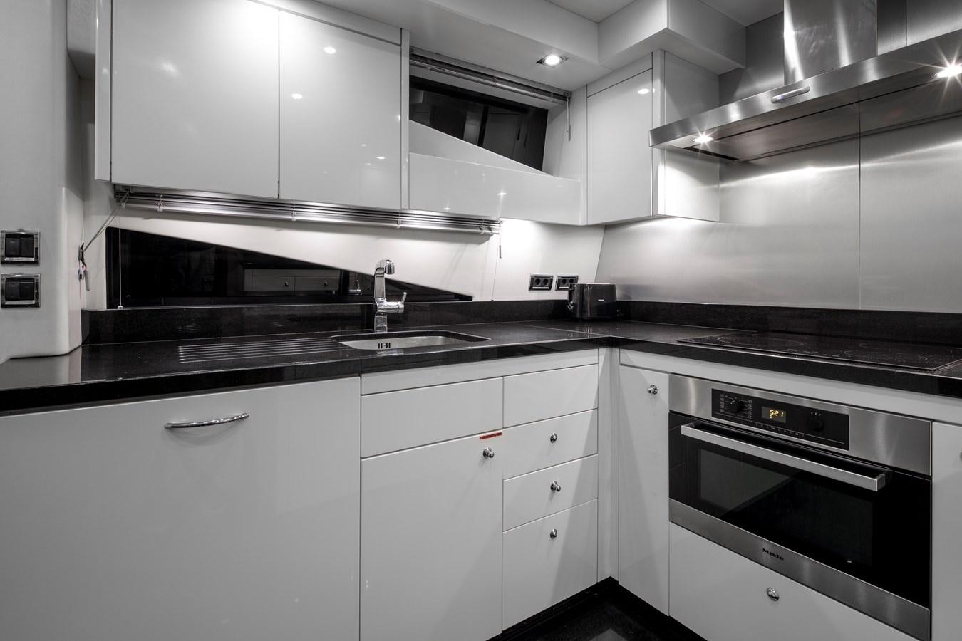 a kitchen with white cabinets aboard SSM Yacht for Sale