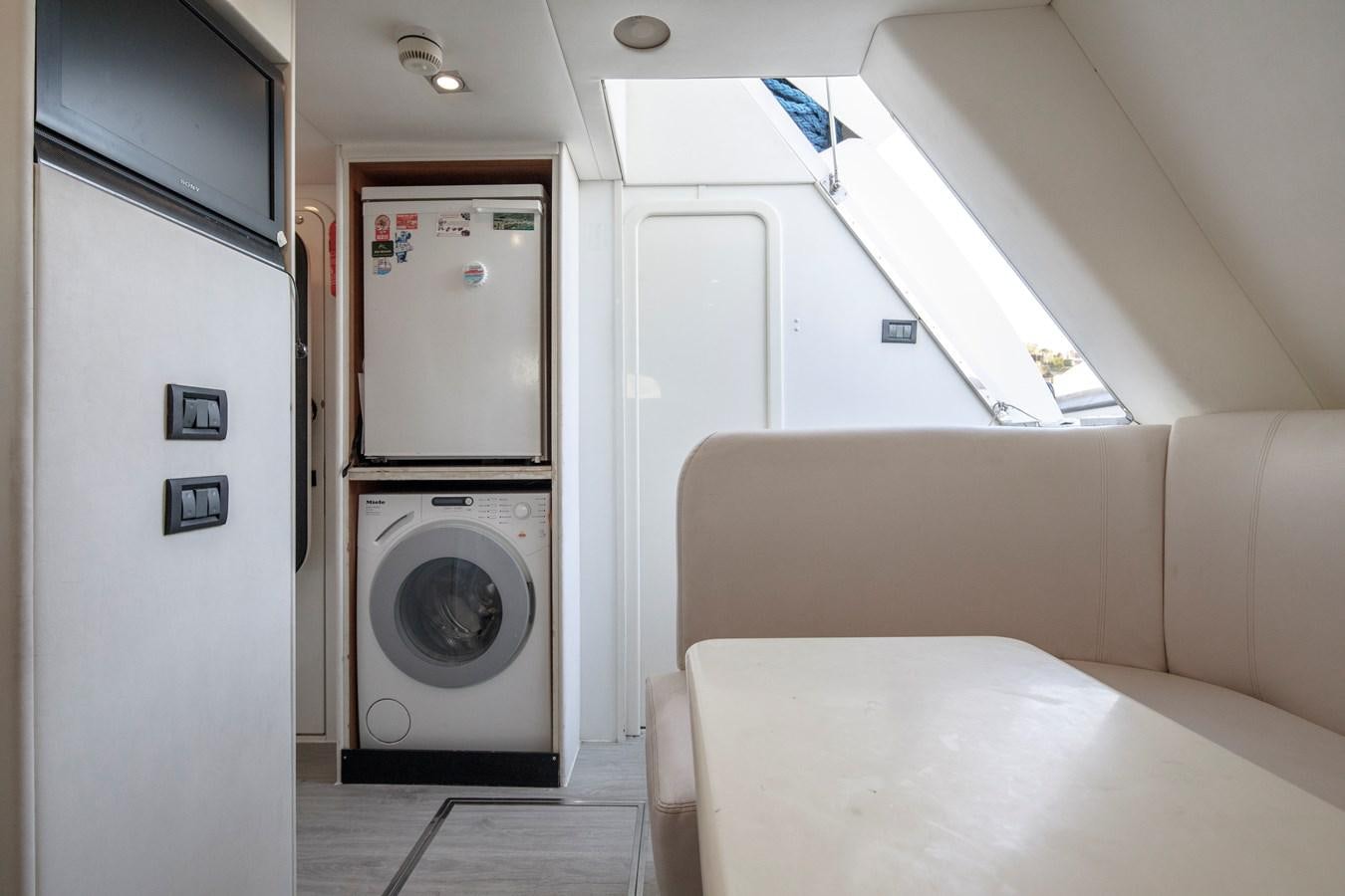 a room with a couch and a washing machine aboard SSM Yacht for Sale