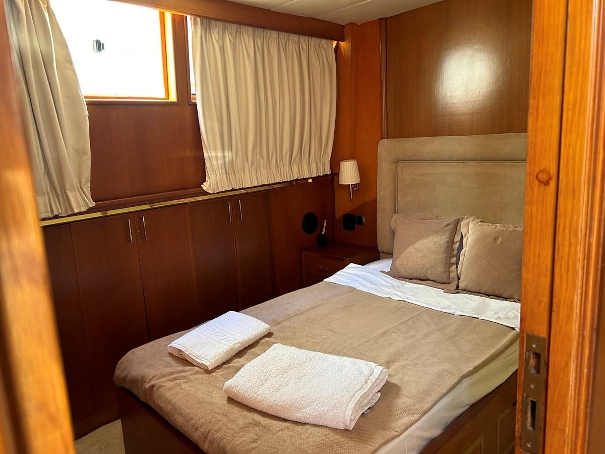 a bed with a book on it aboard MOTORSAILLOR Yacht for Sale