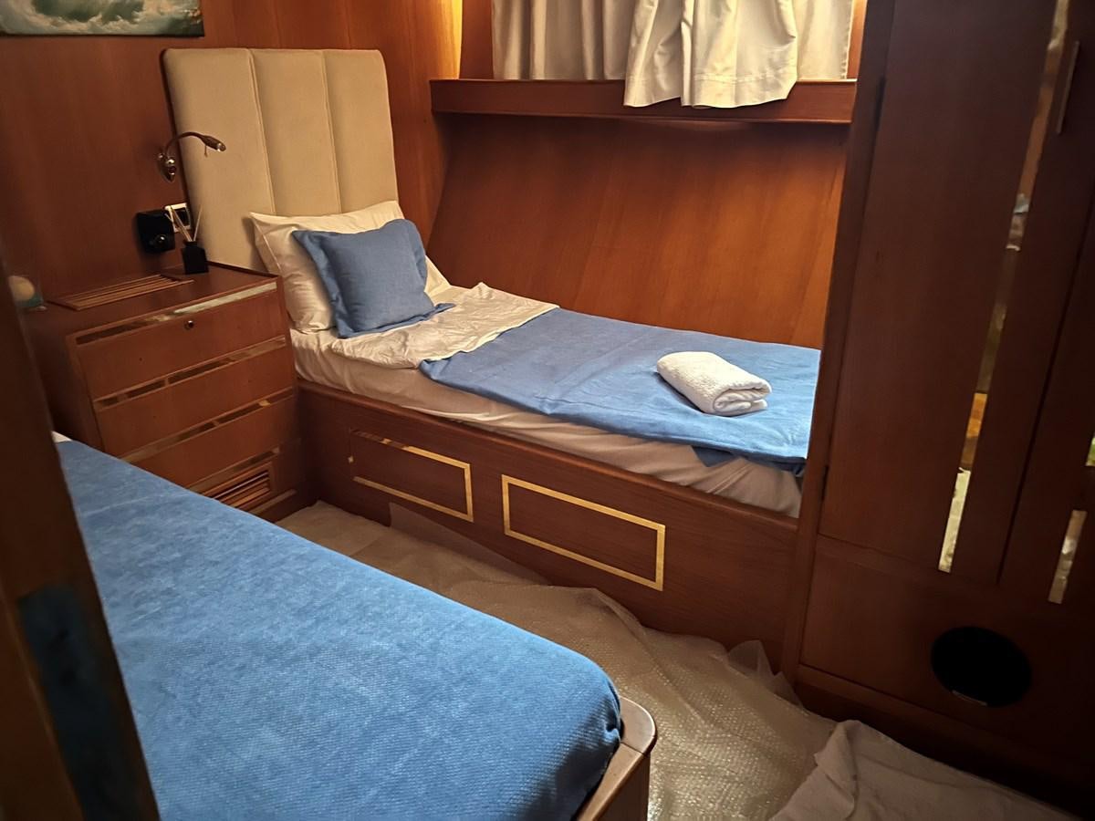 a bed with a blue sheet aboard MOTORSAILLOR Yacht for Sale