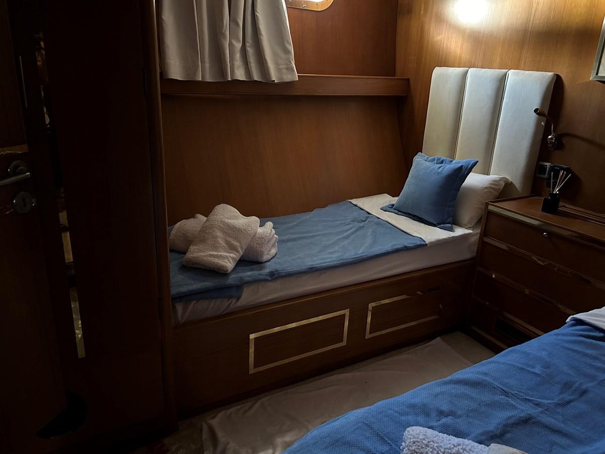 a bed with a blue pillow aboard MOTORSAILLOR Yacht for Sale