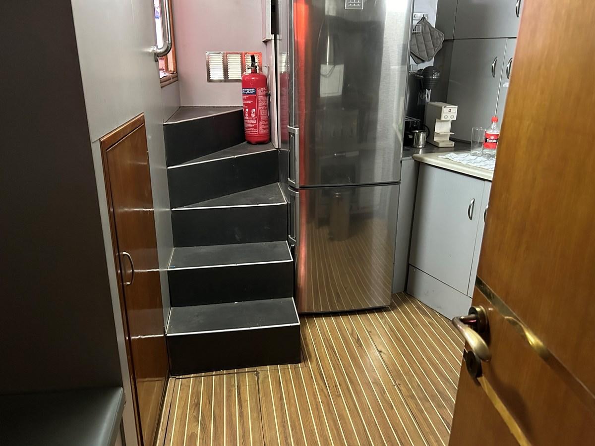 a kitchen with a stainless steel refrigerator aboard MOTORSAILLOR Yacht for Sale
