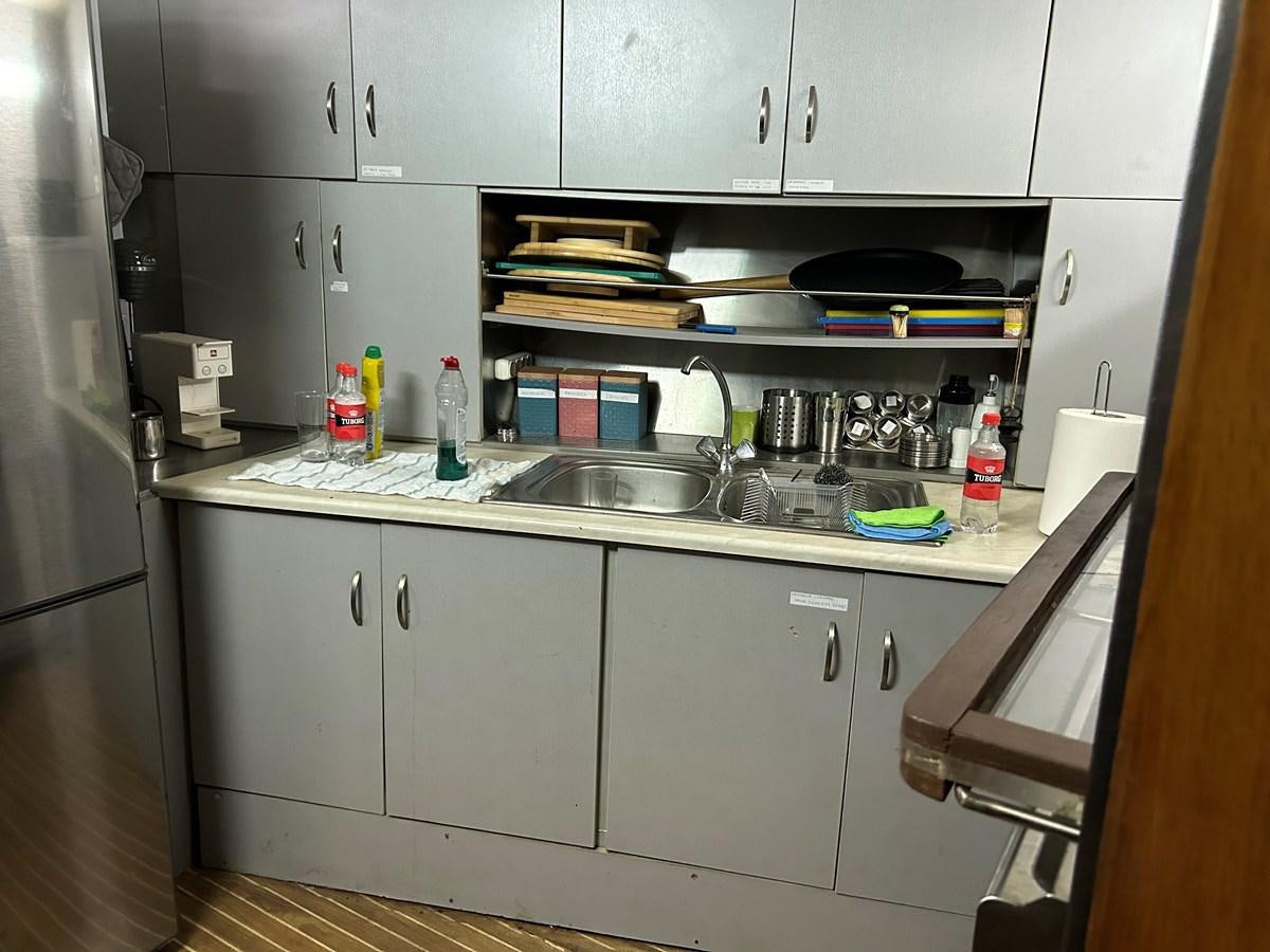 a kitchen with a sink and shelves aboard MOTORSAILLOR Yacht for Sale