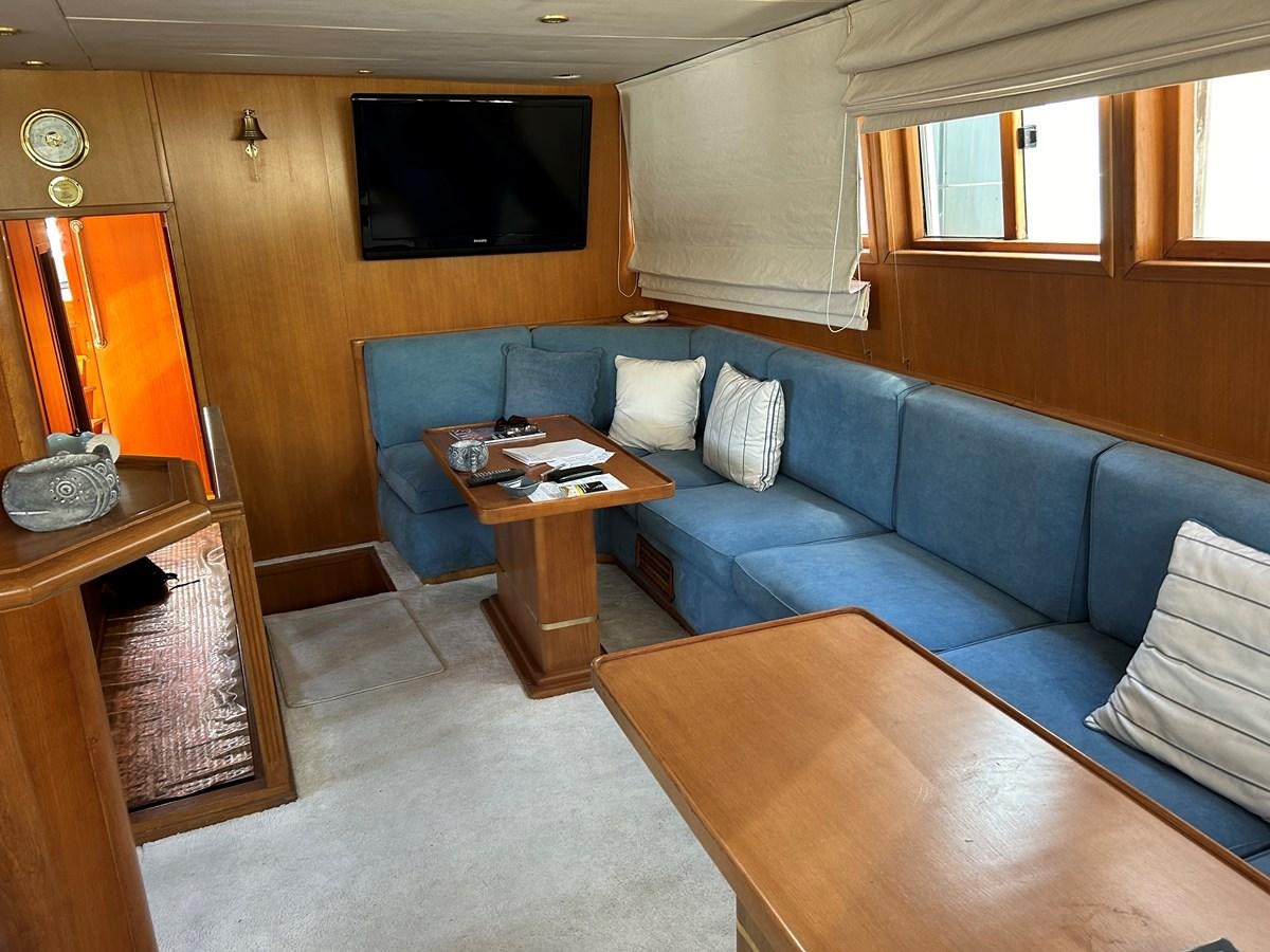 a living room with a blue couch aboard MOTORSAILLOR Yacht for Sale