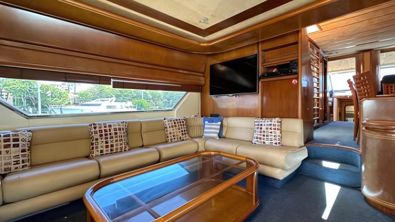 a living room with a table and couches aboard 1998 FERRETTI 80FT Yacht for Sale