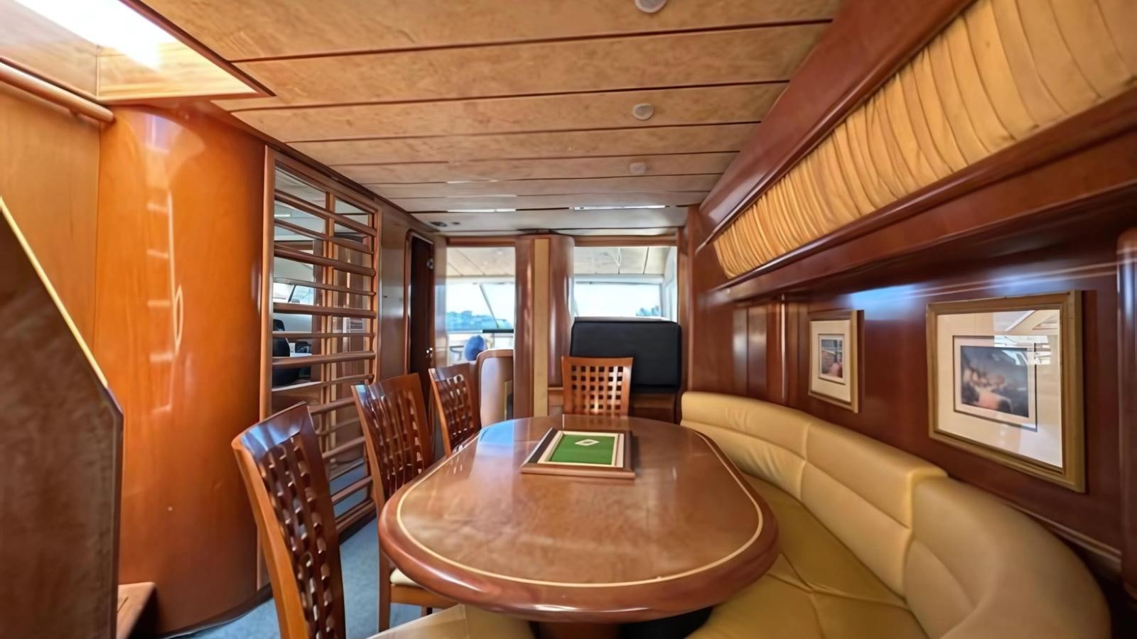 a room with a table and chairs aboard 1998 FERRETTI 80FT Yacht for Sale
