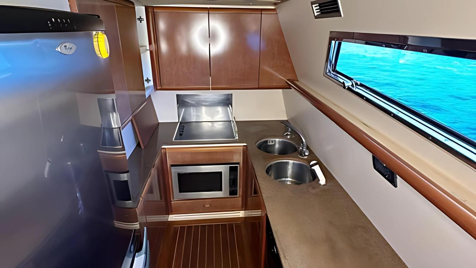 a kitchen with a microwave oven and a sink aboard 1998 FERRETTI 80FT Yacht for Sale