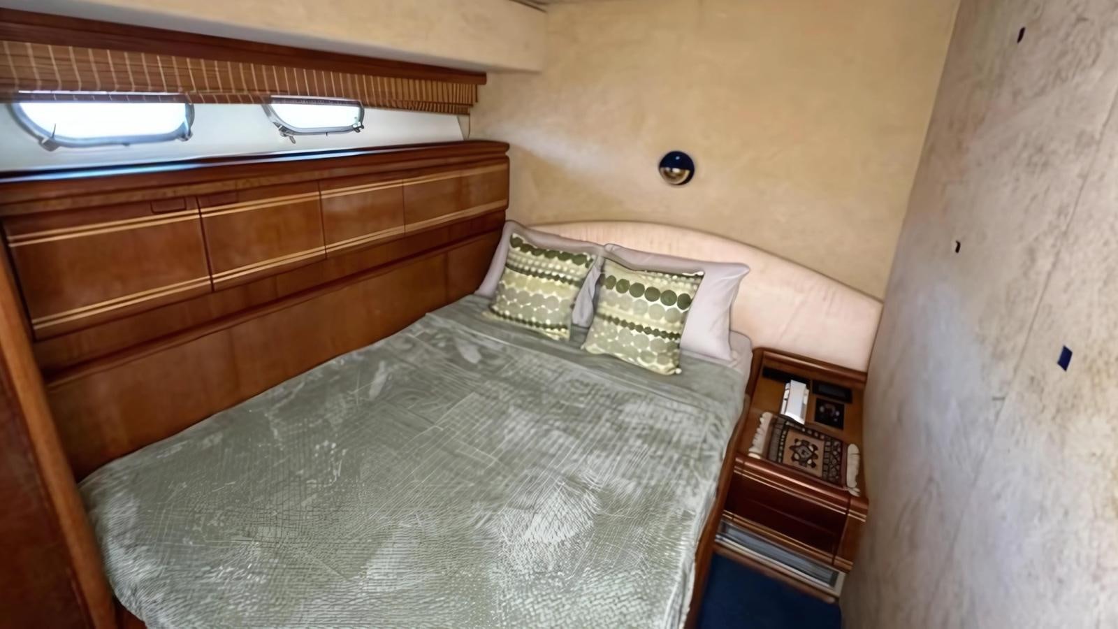 a bed with a wooden headboard aboard 1998 FERRETTI 80FT Yacht for Sale