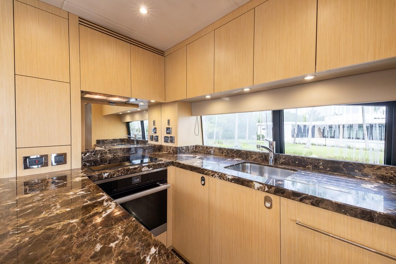 a kitchen with wooden cabinets aboard 2018 SUNSEEKER 75 YACHT Yacht for Sale
