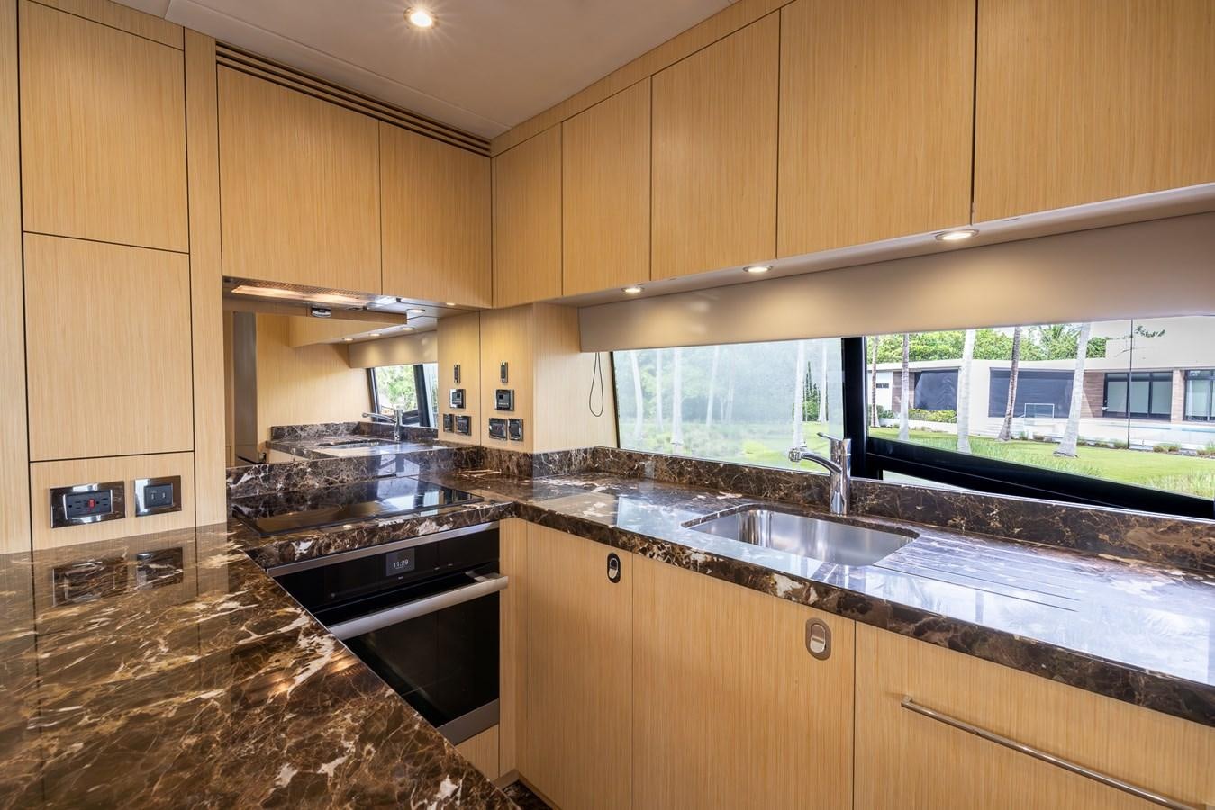 a kitchen with wooden cabinets aboard 2018 SUNSEEKER 75 YACHT Yacht for Sale