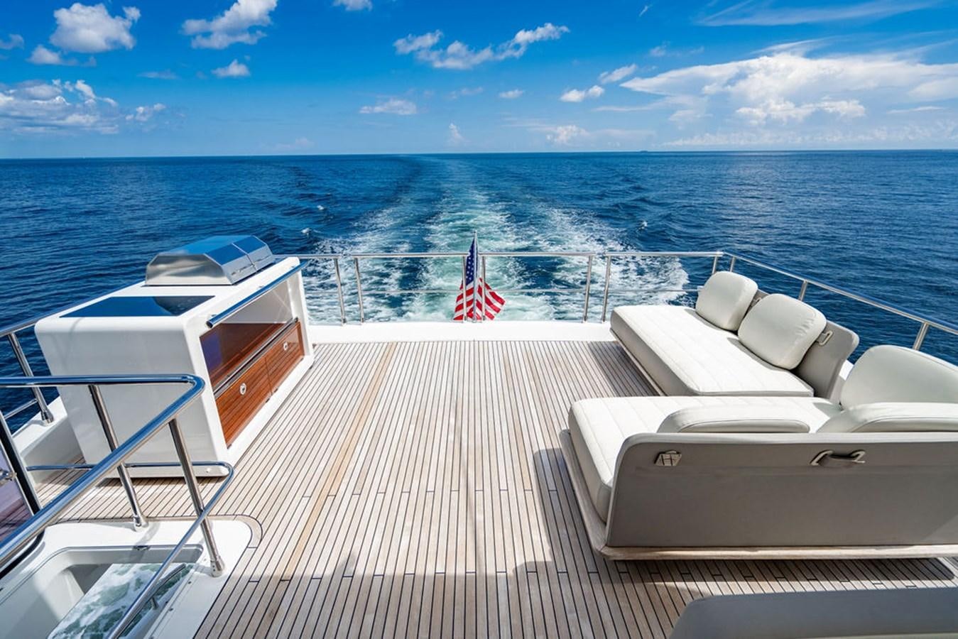 a deck with chairs and a flag on it aboard THE PERFECT MERITAGE Yacht for Sale