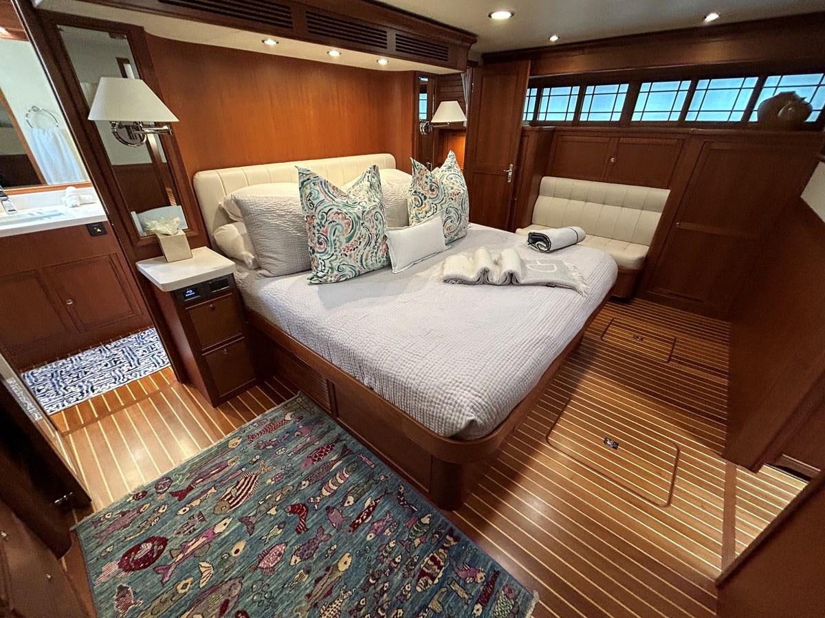 a bed with a blue and white comforter and pillows aboard NOVIA II Yacht for Sale
